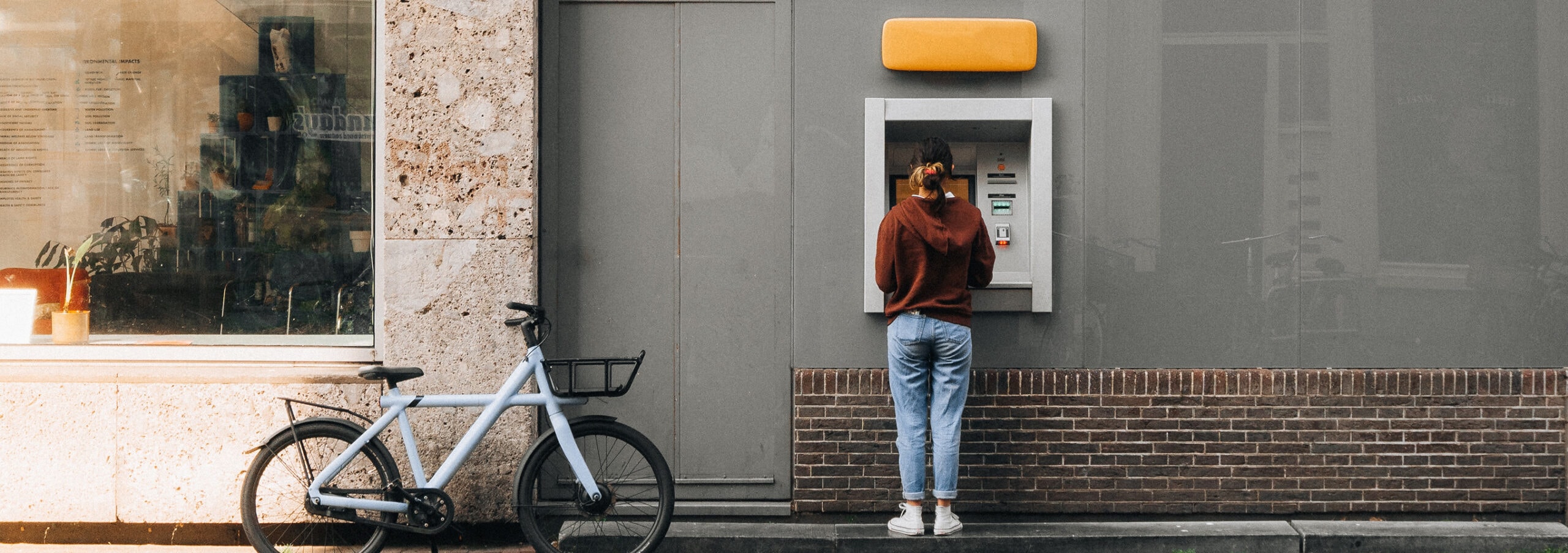 A woman with her bike at the ATM.
